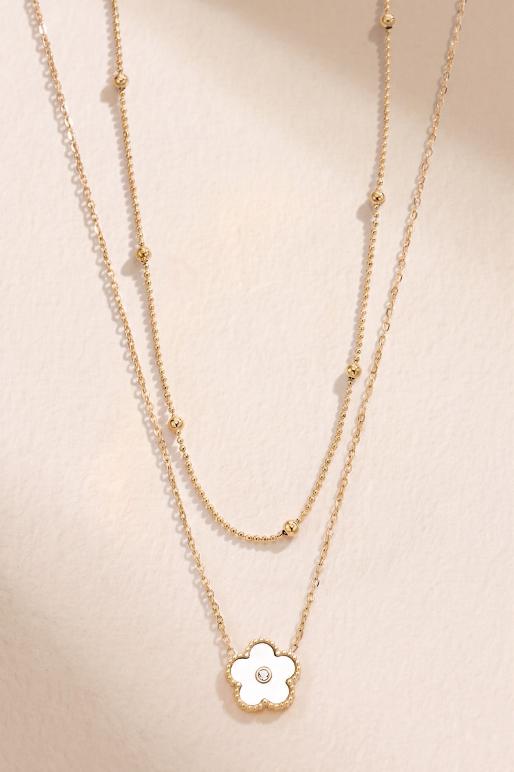 Collier double chaîne avec fleur blanche